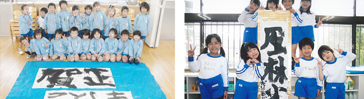 完成した書作品を囲んで満面の笑みの幼児たち
